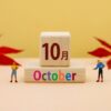 「10月」と「October」と書かれた木製カレンダーが中央に置かれている秋をイメージさせるシンプルで温かみのあるデザイン